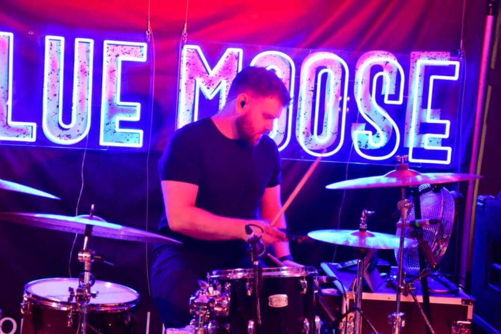 Jason Maleney is playing drums at a concert